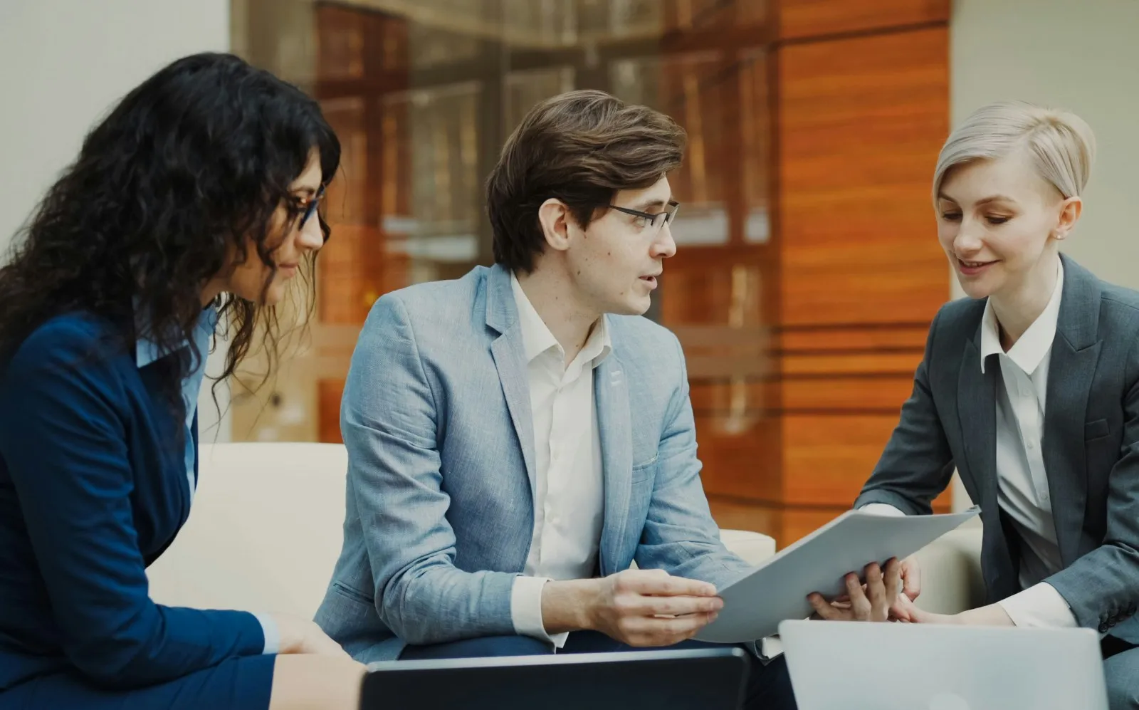 Three colleagues reviewing a document together on a tablet